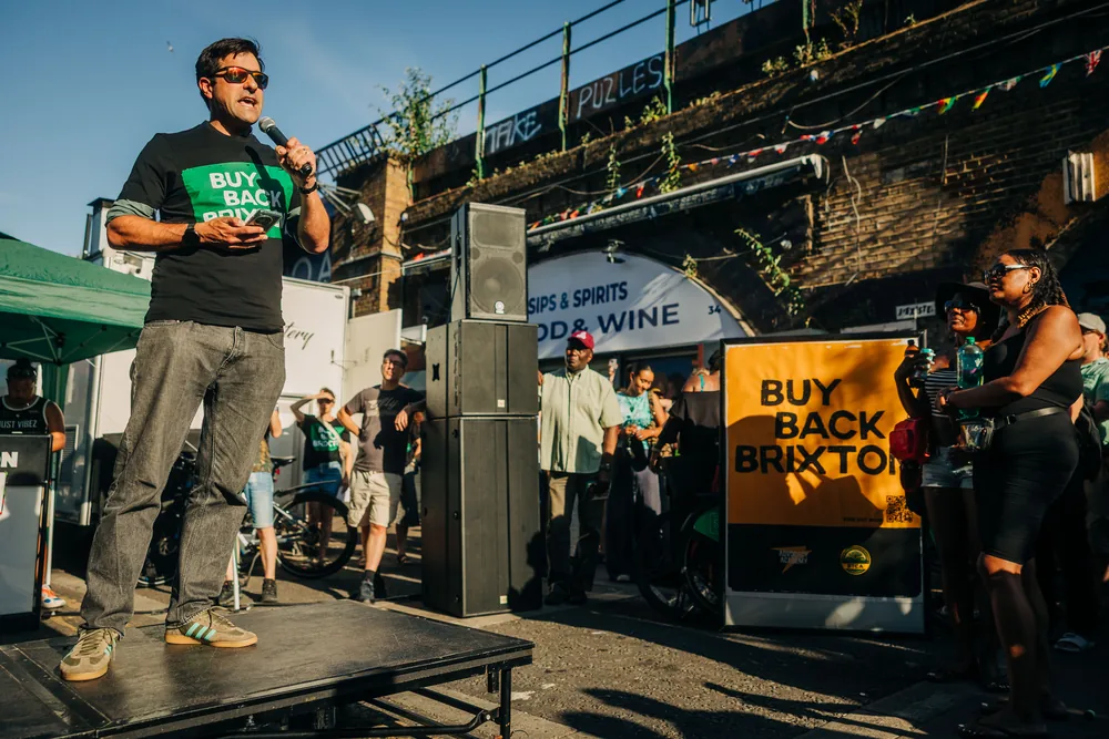 Cllr Martin Abrams, Leader of Lambeth Council, speaking to the rally with a microphone.