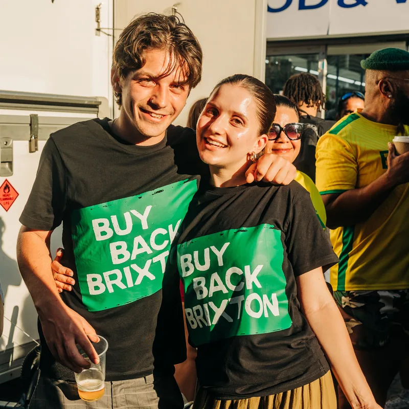 Two young campaigners in Buy Back Brixton T-shirts together in the crowd.