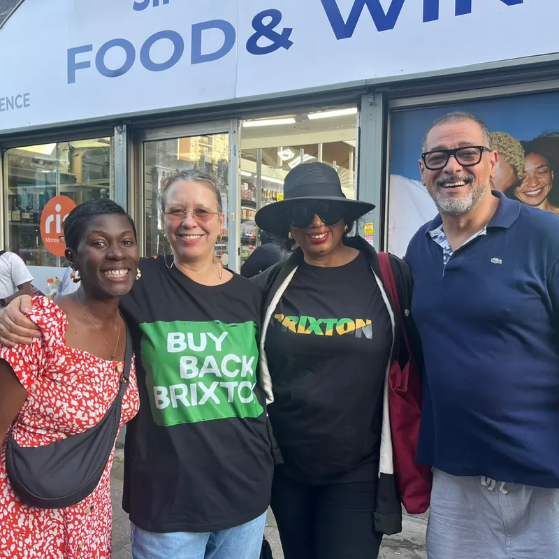 Four supporters posed together outside a shopfront on Station Road.